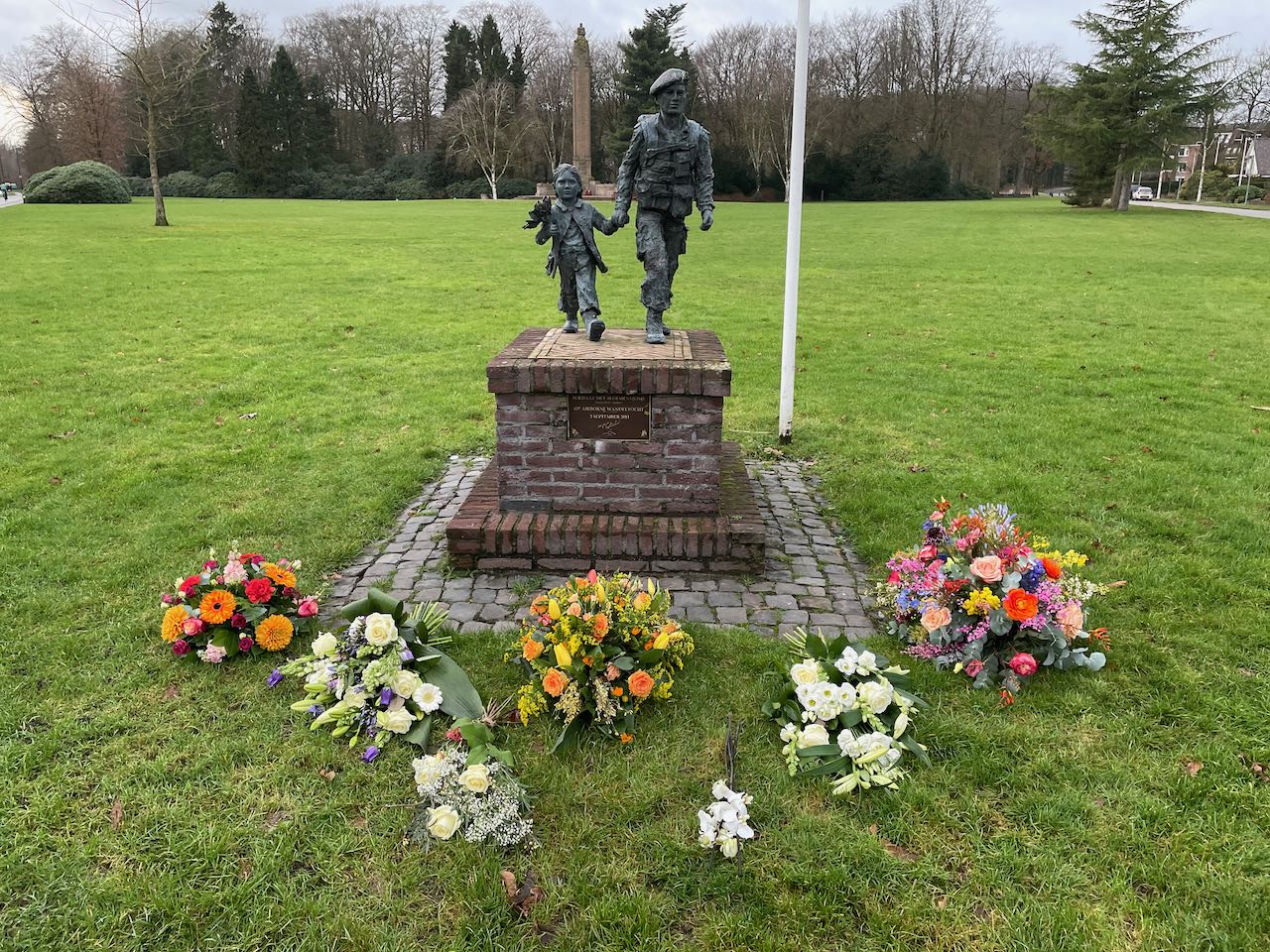 Bloemen van de rouwdienst bij het standbeeld „Meisje met Soldaat“